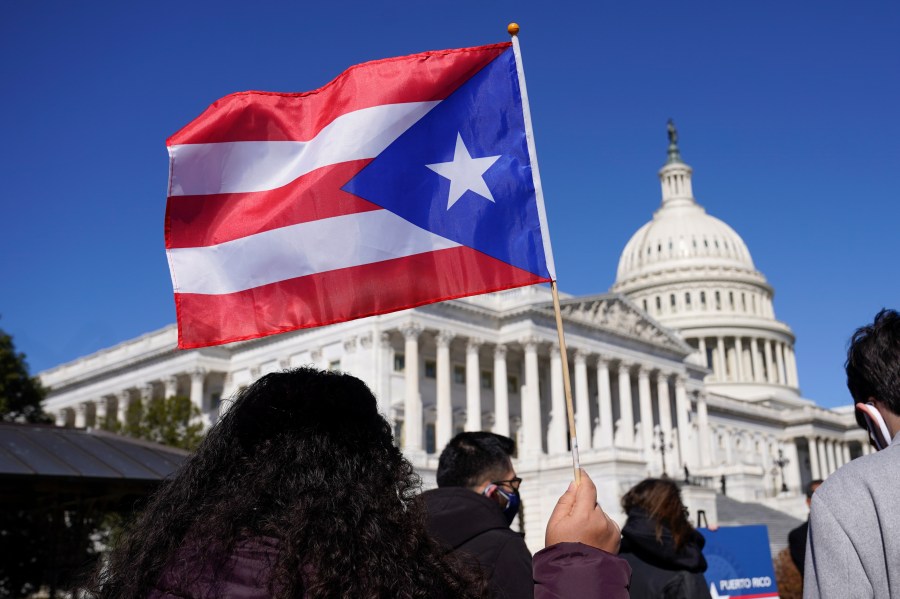 A woman waves the flag of Puerto Rico during a news conference on Puerto Rican statehood