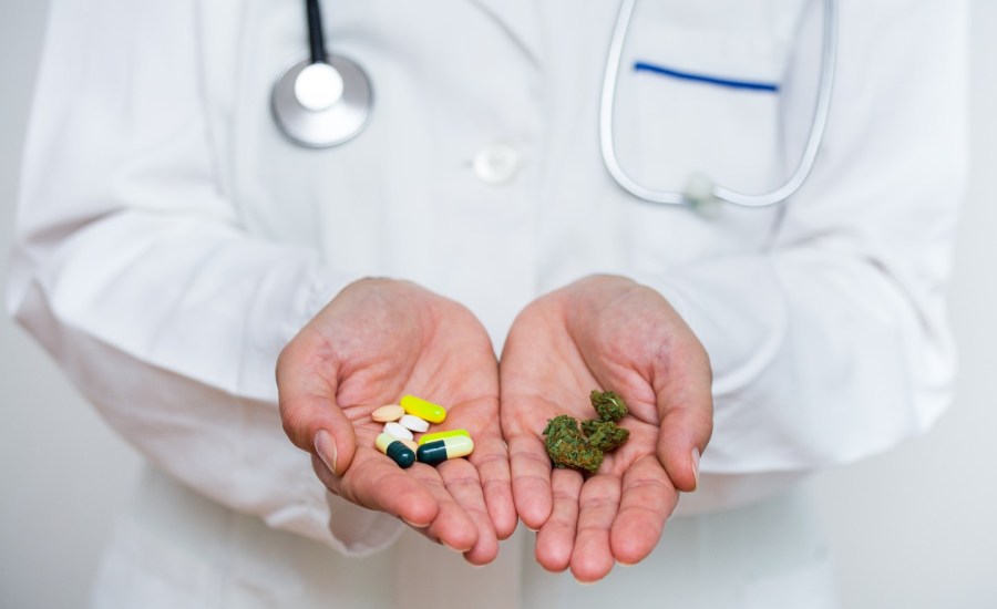 doctor with pills in one hand and medical marijuana in the other