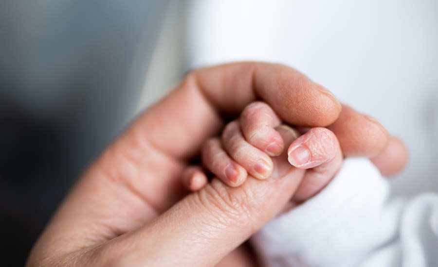 Mother holding child's hand.