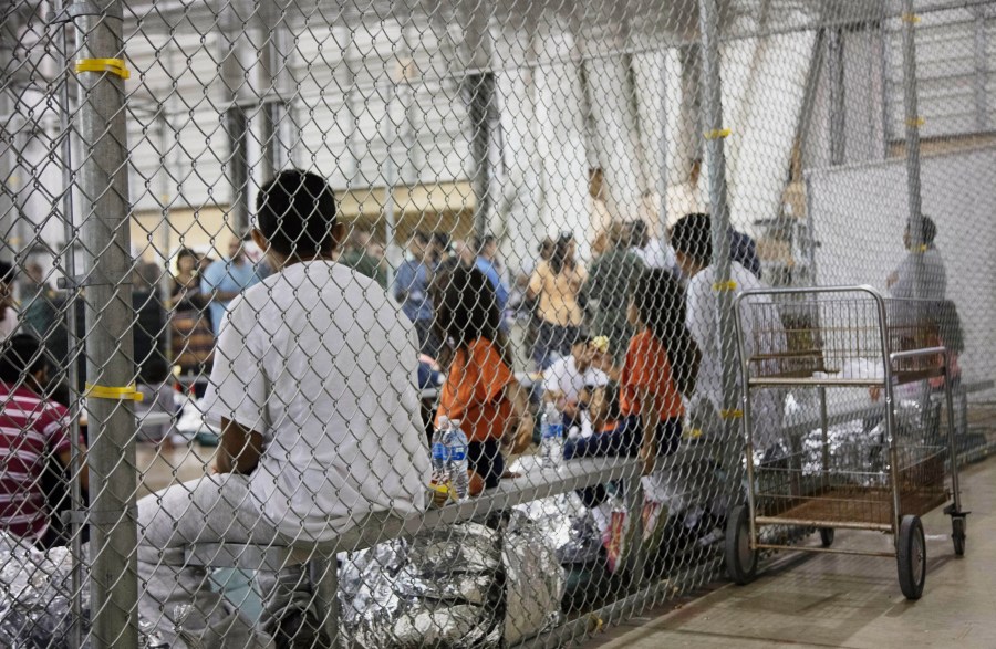 In this photo provided by U.S. Customs and Border Protection, people who've been taken into custody related to cases of illegal entry into the United States, sit in one of the cages at a facility in McAllen, Texas.