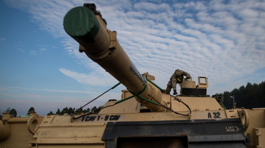 FILE - In this Oct. 21, 2019, file photo a member of the US Army's 1st Armored Battalion of the 9th Regiment, 1st Division from Fort Hood in Texas prepare to unload Abrams battle tanks from rail cars as they arrive at the Pabrade railway station some 50 km (31 miles) north of the capital Vilnius, Lithuania. (AP Photo/Mindaugas Kulbis, File)