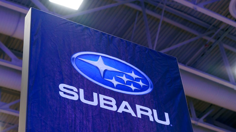 The Subaru logo is seen on a banner at an auto show.