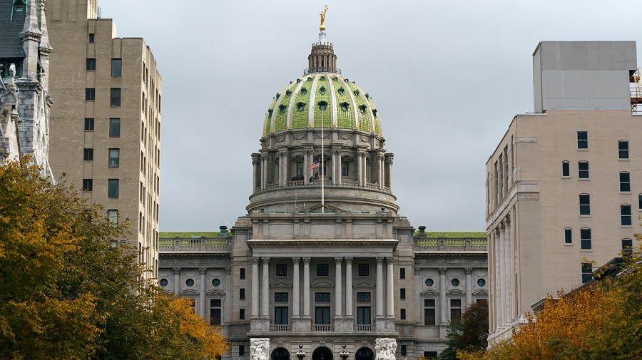 The green top of the Pennsylvania State Capitol is seen against an overcast sky.