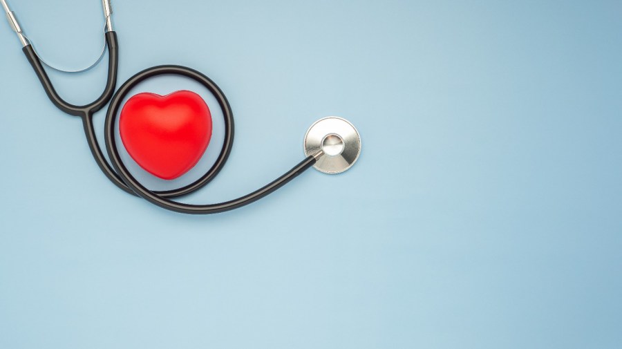 red heart shape with stethoscope on blue background