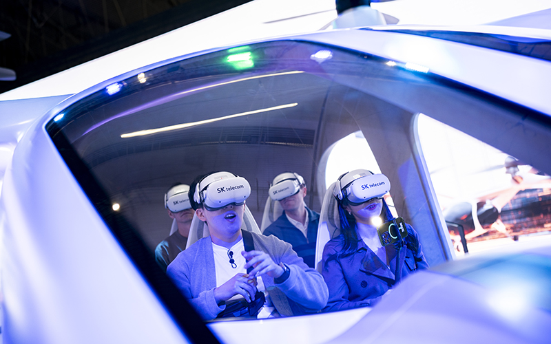 Visitors test a SK Telecom VR flight simulator during the Mobile World Congress 2023