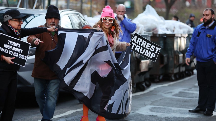 Police, media and a small group of protesters gather outside of a Manhattan courthouse after news broke that former President Trump has been indicted