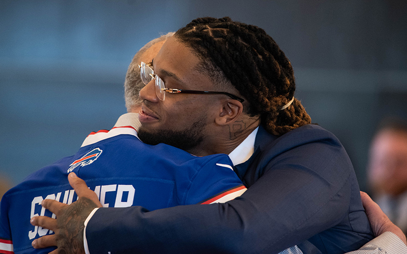 Buffalo Bills safety Damar Hamlin hugs Senate Majority Leader Chuck Schumer (D-N.Y.) during an event