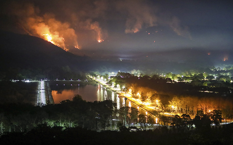 Fire and smoke rise from a forest fire in the Nakhon Nayok province, 70 miles northeast of Bangkok, Thailand