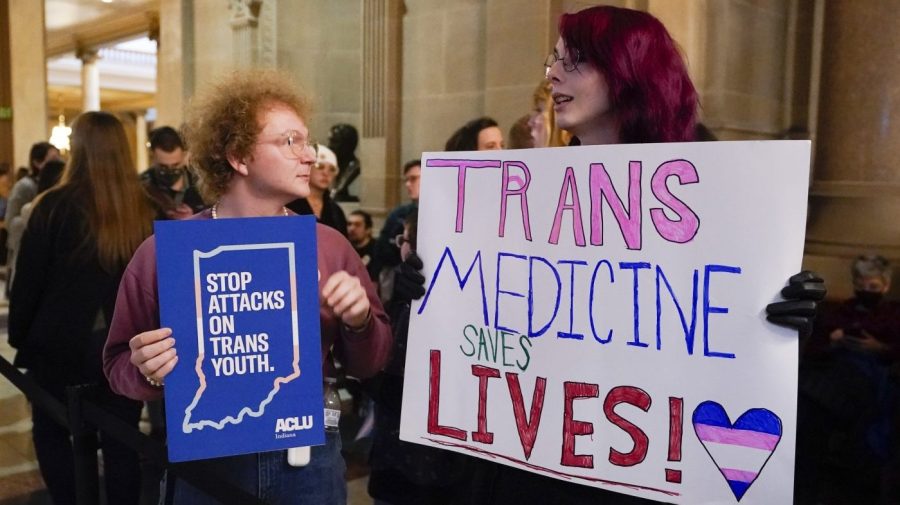 FILE - Protesters stand outside of the Senate chamber at the Indiana Statehouse on Feb. 22, 2023, in Indianapolis. Republican Governors in Indiana and Idaho have signed into law bills banning gender-affirming care for minors early April 2023, making those states the latest to prohibit transgender health care this year. (AP Photo/Darron Cummings, File)