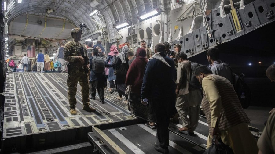 FILE - In this Aug. 22, 2021, file photo provided by the U.S. Air Force, Afghan passengers board a U.S. Air Force C-17 Globemaster III during the Afghanistan evacuation at Hamid Karzai International Airport in Kabul, Afghanistan. (MSgt. Donald R. Allen/U.S. Air Force via AP, File)