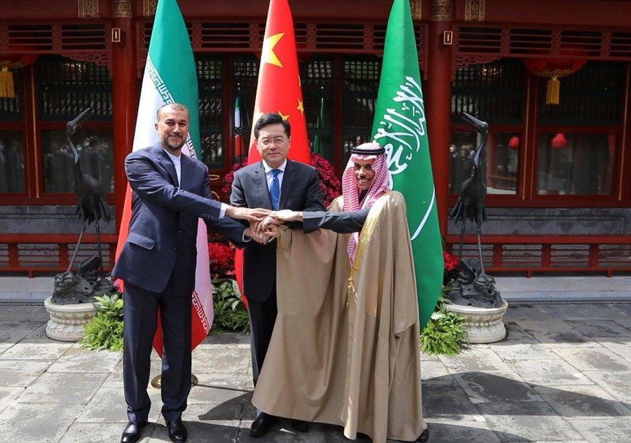 In this picture released by the Iranian Foreign Ministry, Iran's Foreign Minister Hossein Amirabdollahian, left, shakes hands with his Saudi Arabian counterpart Prince Faisal bin Farhan Al Saud, right, and Chineses counterpart Qin Gang in Beijing Thursday, April 6, 2023. (Iranian Foreign Ministry via AP)