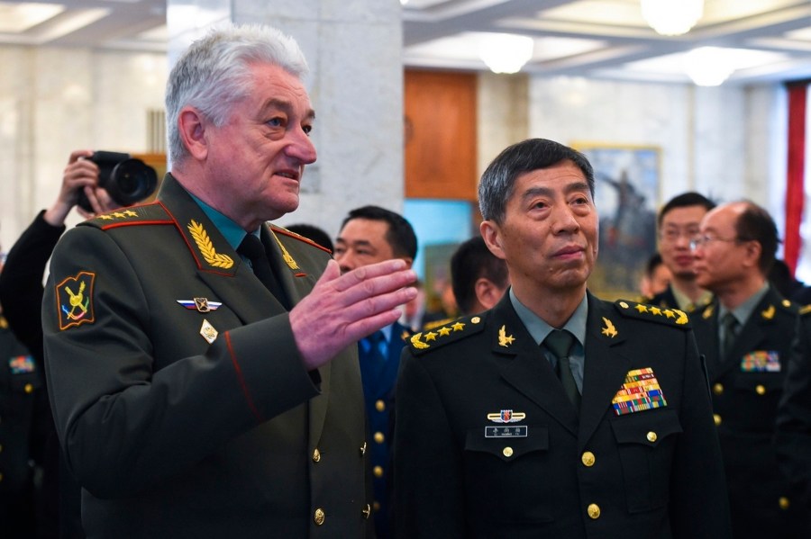 In this handout photo released by Russian Defense Ministry Press Service, Chief of the Military Academy of the General Staff of the Armed Forces of the Russian Federation Col. Gen. Vladimir Zarudnitsky, left, escorts China's Defense Minister Gen. Li Shangfu during a visit to Military Academy of the General Staff of the Armed Forces of the Russian Federation in Moscow, Russia, Monday, April 17, 2023. (Russian Defense Ministry Press Service via AP)