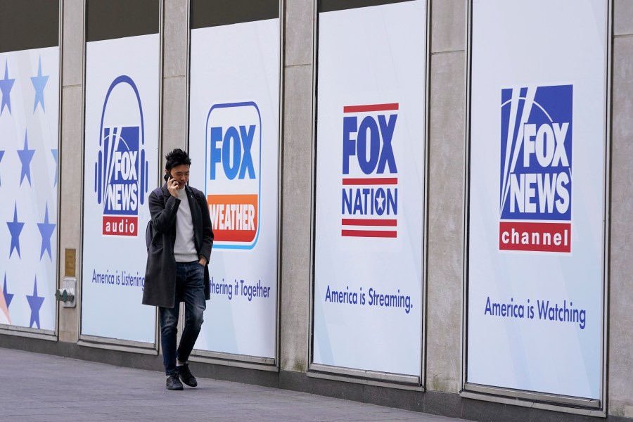 File - A man walks past the News Corp. and Fox News headquarters on Wednesday, April 19, 2023, in New York. Fox Corp.'s hefty $787.5 million settlement with Dominion over defamation charges is unlikely to make a dent in Fox's operations, analysts say. (AP Photo/Mary Altaffer, File)