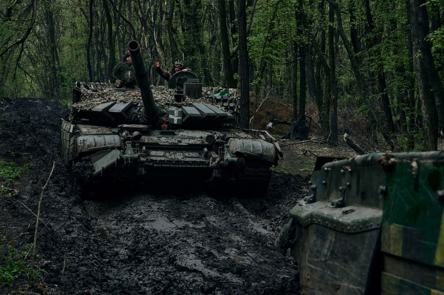 Ukrainian soldiers wave atop a passing tank on the frontline in Bakhmut, Donetsk region, Ukraine, Sunday, April 23, 2023. (AP Photo/Libkos)