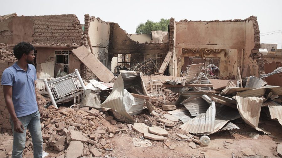 A man walks by a house hit in recent fighting in Khartoum, Sudan, Tuesday, April 25, 2023. Sudan's warring generals have pledged to observe a new three-day truce that was brokered by the United States and Saudi Arabia to try to pull Africa's third-largest nation from the abyss. (AP Photo/Marwan Ali)