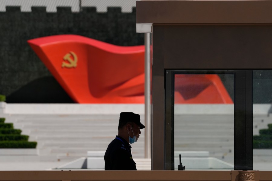 A security guard stands near a sculpture of the Chinese Communist Party flag at the Museum of the Communist Party of China on May 26, 2022, in Beijing.