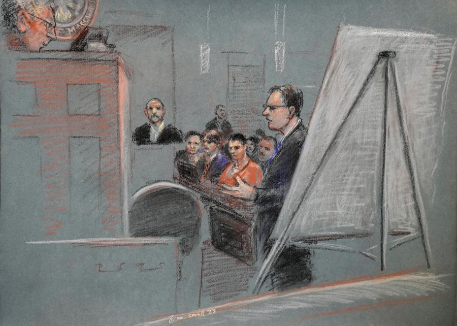 In this artist depiction, Massachusetts Air National Guardsman Jack Teixeira, center, is seated as defense attorney Brendan Kelley stands and speaks, at right, and his father Jack Michael Teixeira is seated in the witness stand, during a detention hearing in federal court, Thursday, April 27, 2023, in Worcester, Mass. Magistrate Judge David Hennessy in Teixeira's detention hearing put off an immediate decision on whether he should be kept in custody until his trial or released to home confinement or under other conditions. (Margaret Small via AP)