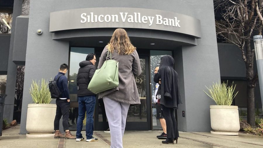 File - People stand outside a Silicon Valley Bank branch in Santa Clara, Calif., Friday, March 10, 2023. The Federal Reserve is scheduled Friday to release a highly-anticipated review of its supervision of Silicon Valley Bank, the go-to bank for venture capital firms and technology start-ups that failed spectacularly in March. (AP Photo/Jeff Chiu, File)