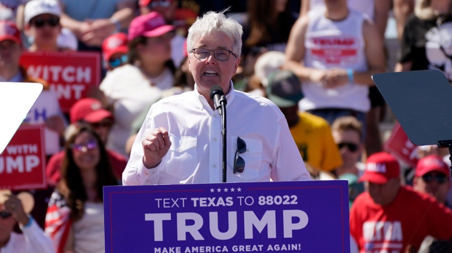 Texas Lt. Gov. Dan Patrick gestures while speaking at a campaign event behind a crowd of supporters.