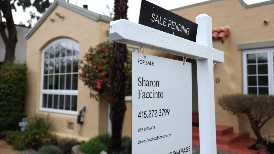 A sale pending sign is posted outside a house.