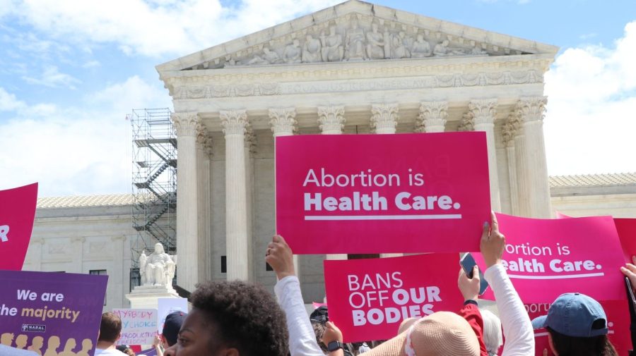 Protesters in front of the Supreme Court hold up signs that say "Abortion is Health Care."