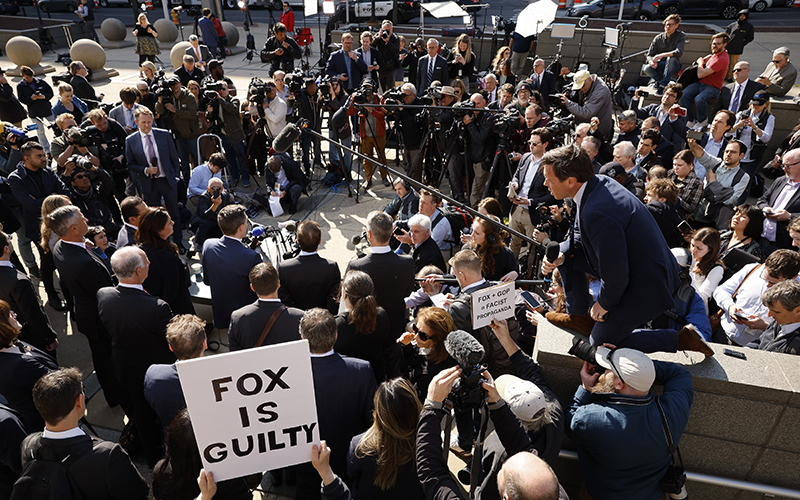 Lawyers representing Dominion Voting Systems talk to a crowd of reporters