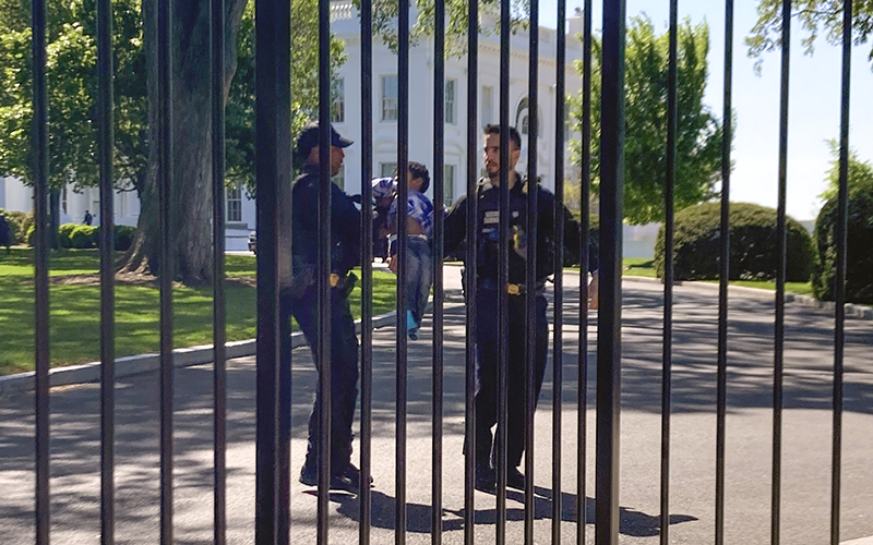 Secret Service uniformed division police officers carry a young child who crawled through the White House fence