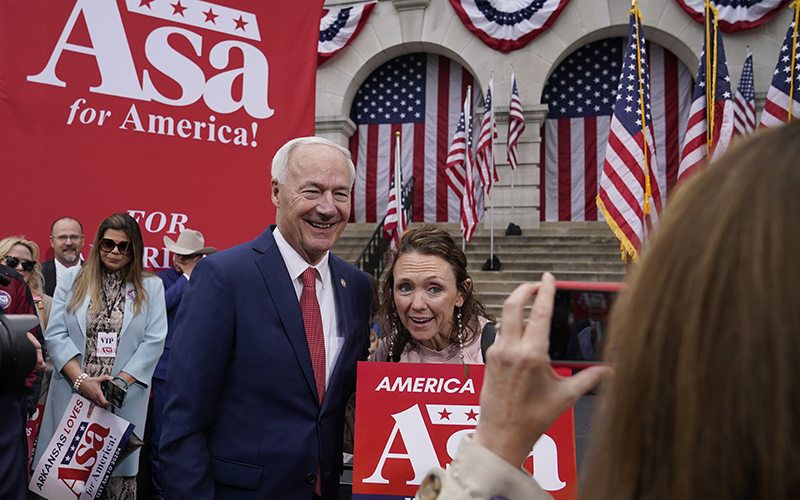 Former Arkansas Gov. Asa Hutchinson poses for a photo with a supporter