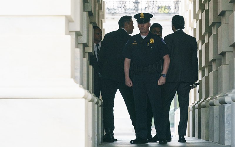 Police stand by as Elon Musk leaves the Capitol following a meeting with Senate Majority Leader Chuck Schumer