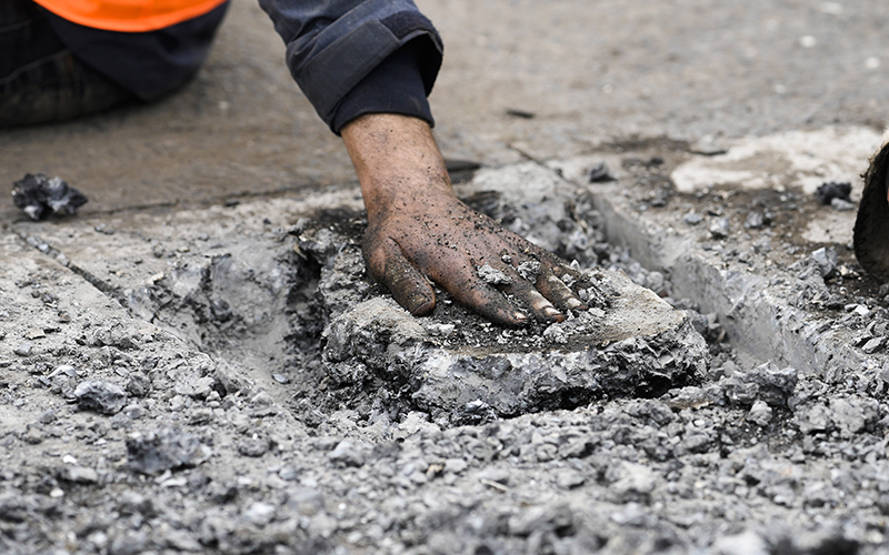 Police remove the asphalt next to the hand of a climate activist who glued his hand to the road