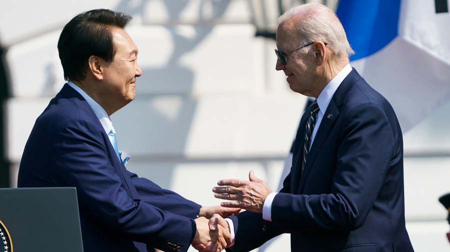 South Korean President Yoon Suk Yeol shakes hands with President Biden