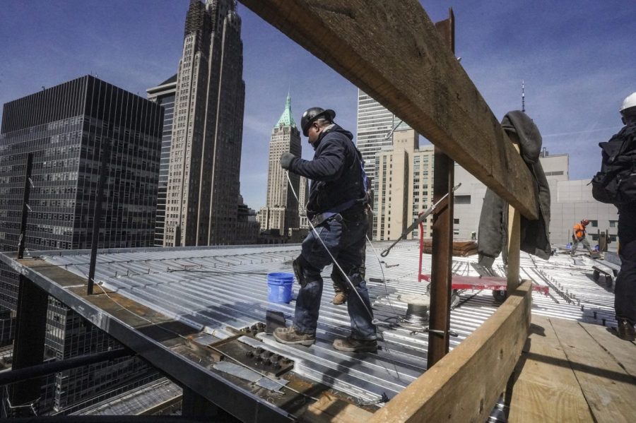 File - Construction workers install roofing on a high rise in Manhattan's financial district on Tuesday, April 11, 2023, in New York. On Friday, the U.S. government issues the April jobs report. (AP Photo/Bebeto Matthews, File)