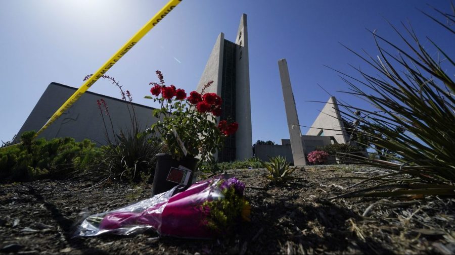 FILE - Flowers sit near crime scene tape at Geneva Presbyterian Church, Tuesday, May 17, 2022, in Laguna Woods, Calif., after a fatal shooting at the church. David Chou, of Las Vegas, suspected of killing one person and wounded five others when he shot up a Southern California church luncheon last year, has been charged with dozens of federal hate crimes in connection with the attack, which investigators say was motivated by political hatred of Taiwan, according to n indictment released Thursday, May 11, 2023, by the U.S. Department of Justice. Chou, is charge with 98 counts including weapons and explosives charges and obstructing the free exercise of religion with force. (AP Photo/Ashley Landis, File)