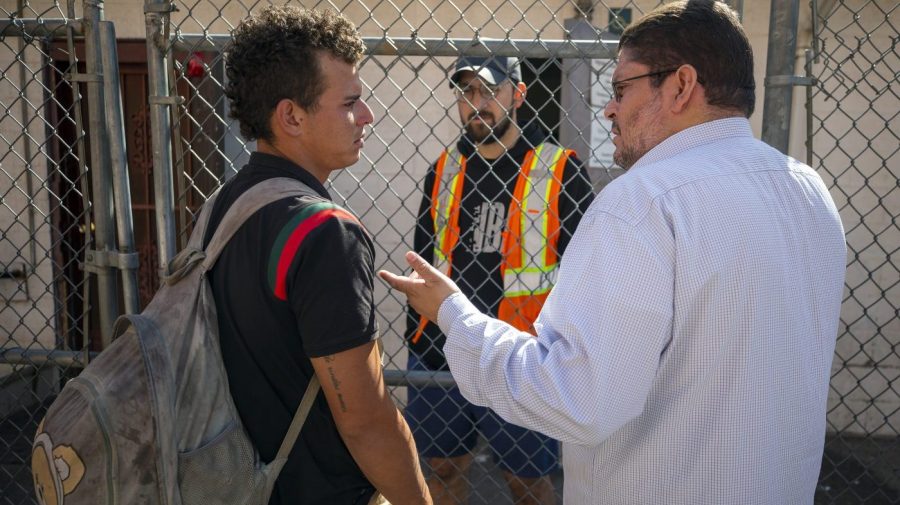 Venezuelan migrant Said Jose, left, asks for help from Jesuit priest Daniel Mora while looking his girlfriend who he got separated with during his detention, at the shelter run by the Sacred Heart Church in El Paso, Texas, Friday, May 12, 2023. The border between the U.S. and Mexico was relatively calm Friday, offering few signs of the chaos that had been feared following a rush by worried migrants to enter the U.S. before the end of pandemic-related immigration restrictions. (AP Photo/Andres Leighton)