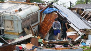 People salvage items from a home after a tornado hit Saturday, May 13, 2023, in the unincorporated community of Laguna Heights, Texas near South Padre Island. Authorities say one person was killed when a tornado struck the southernmost tip of Texas on the Gulf coast. (AP Photo/Julio Cortez)
