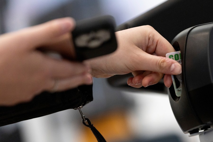 A traveler inserts her ID card while using the Transportation Security Administration's new facial recognition technology at a Baltimore-Washington International Thurgood Marshall Airport security checkpoint, Wednesday, April 26, 2023, in Glen Burnie, Md. (AP Photo/Julia Nikhinson)