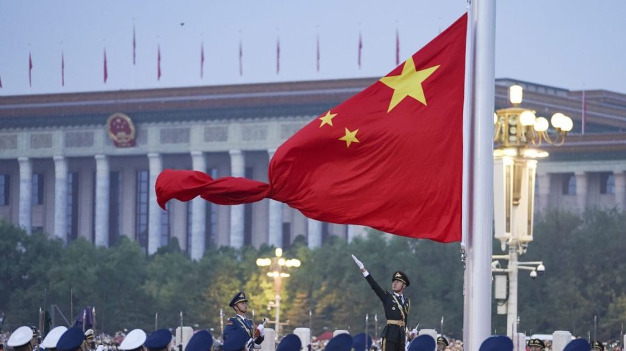 FILE - In this photo released by Xinhua News Agency, a member of the Chinese honor guard unfurls the Chinese national flag during a flag raising ceremony to mark the 73rd anniversary of the founding of the People's Republic of China held at the Tiananmen Square in Beijing on Oct. 1, 2022. Leaders of the Group of Seven advanced economies are generally united in voicing concern about China. The question is how to translate that worry into action.(Chen Zhonghao/Xinhua via AP, File)