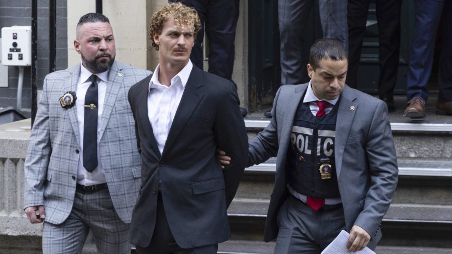 FILE - Daniel Penny, center, is walked by New York Police Department detectives out of the 5th Precinct on May. 12, 2023, in New York. Republican presidential hopefuls have rushed to support Penny, a white U.S. Marine veteran who was caught on video pinning an agitated Black subway passenger to the floor in a fatal chokehold.(AP Photo/Jeenah Moon, File)