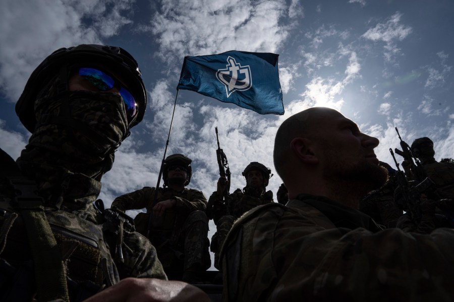 Fighters of Russian Volunteer Corps stand atop on an APC during press conference not far from the border in Sumy region, Ukraine, Wednesday, May 24, 2023. Russia's military said Tuesday it quashed what appeared to be one of the most serious cross-border attacks from Ukraine since the war began, claiming to have killed more than 70 attackers in a battle that lasted around 24 hours. (AP Photo/Evgeniy Maloletka)