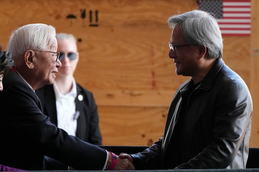 File - Taiwan Semiconductor Manufacturing Company founder Morris Chang, left, shakes hands with Nvidia Co-founder, President, and CEO Jensen Huang, right, at the TSMC facility under construction in Phoenix, Tuesday, Dec. 6, 2022. Nvidia shares skyrocketed early Thursday after the chipmaker forecast a huge jump in revenue for the next quarter, notably pointing to chip demand for AI-related products and services.(AP Photo/Ross D. Franklin, File)