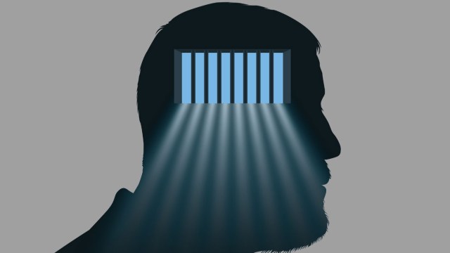 Concept of depression and psychic problems with the symbol of a man whose brain is imprisoned behind bars.