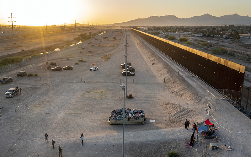 A small group of migrants are seen camping outside the border fence