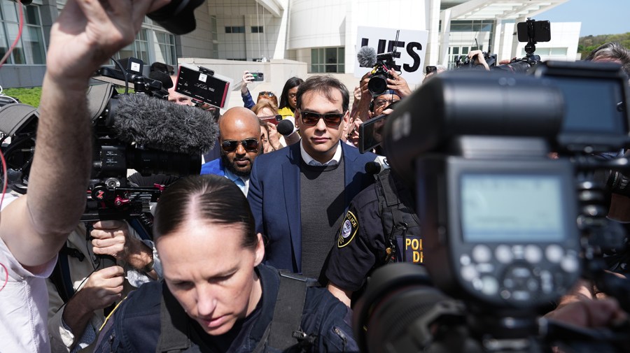 Rep. George Santos (R-N.Y.) leaves the Long Island Federal Courthouse surrounded by reporters and cameras