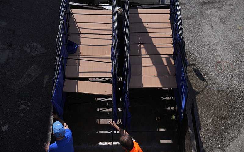 Municipal workers, bottom center, unload a truck with polling booths, in Athen