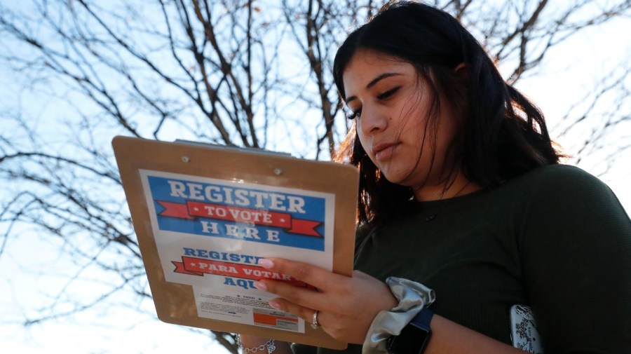 FILE - Karina Shumate, 21, a college student studying stenography, fills out a voter registration form in Richardson, Texas, on Jan. 18, 2020. (AP Photo/LM Otero, File)