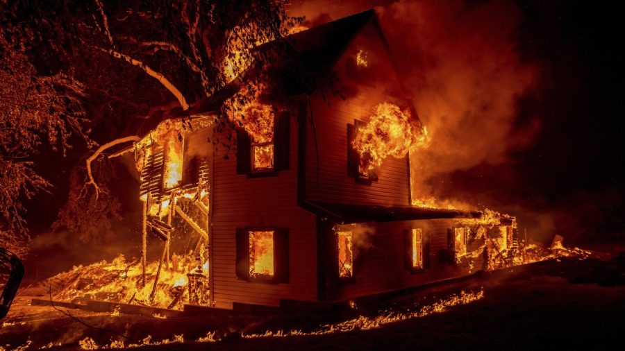 FILE - A home burns as the Dixie fire jumps Highway 395 south of Janesville, Calif., Aug. 16, 2021. Two insurance industry giants have pulled out of the California marketplace, saying that wildfire risk and the soaring cost of construction prompted them to stop writing new policies in the nation's most populous state. (AP Photo/Ethan Swope, File)