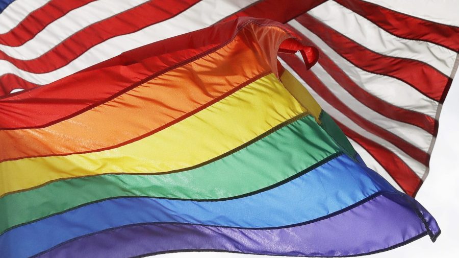 FILE - The LGBTQ+ pride flag flies beneath the American flag at the Stonewall National Monument, Oct. 11, 2017, in New York. Veterans Affairs Secretary Denis McDonough has authorized flying of the LGBTQ+ pride flag at all VA facilities throughout Pride Month, VA Press Secretary Terrence Hayes said in a statement on Tuesday, June 6, 2023. (AP Photo/Mark Lennihan, File)