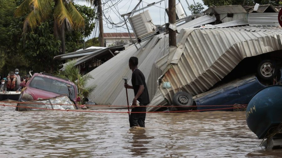 FILE - In this Nov. 6, 2020, file photo, a resident walking through a flooded street looks back at storm damage caused by Hurricane Eta in Planeta, Honduras. Environmental campaigners called Wednesday for fossil fuel producers to contribute to a new fund intended to help poor countries cope with climate disasters. (AP Photo/Delmer Martinez, File)