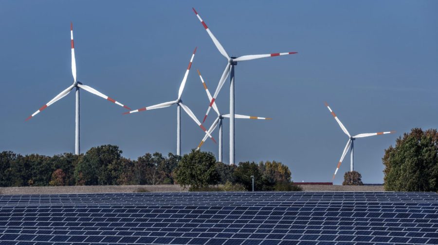 FILE - Wind turbines turn behind a solar farm in Rapshagen, Germany, Oct. 28, 2021. Germany has called for governments around the world to work on setting an ambitious target for renewable energy that would "ring in the end of the fossil fuel age" and help prevent dangerous global warming. Germany welcomed a deal Friday, June 16, 2023 among European Union countries to increase by more than a third the bloc’s renewable energy target for 2030. (AP Photo/Michael Sohn, File)