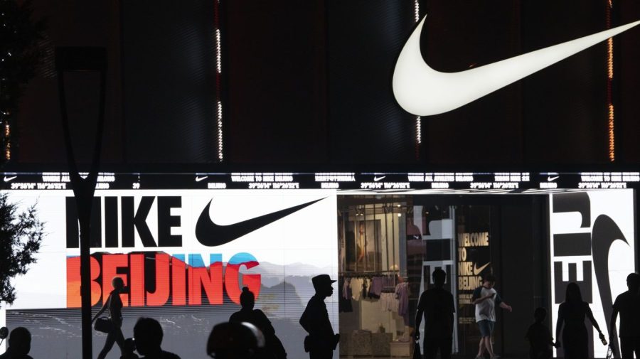 Residents are silhouetted outside a mall in Beijing, Sunday, June 18, 2023. Chinese merchants offered customers steep discounts during China's first major online shopping festival after the COVID-19 pandemic, in the hopes of shoring up sales amid a weaker-than-expected recovery in consumption. (AP Photo/Ng Han Guan)